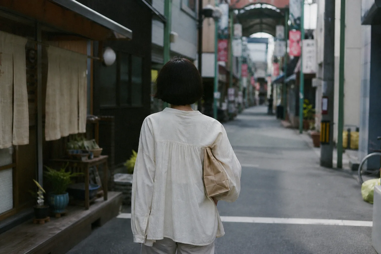 紙袋を抱えて歩く後ろ姿