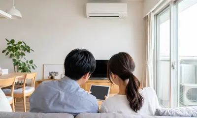 タブレットを見ながら相談する夫婦の後ろ姿